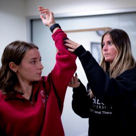 Occupational therapist assessing patient's arm