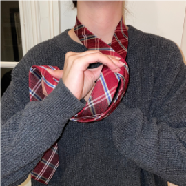 person tieing a tie