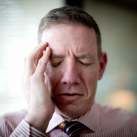 man holding his head in pain