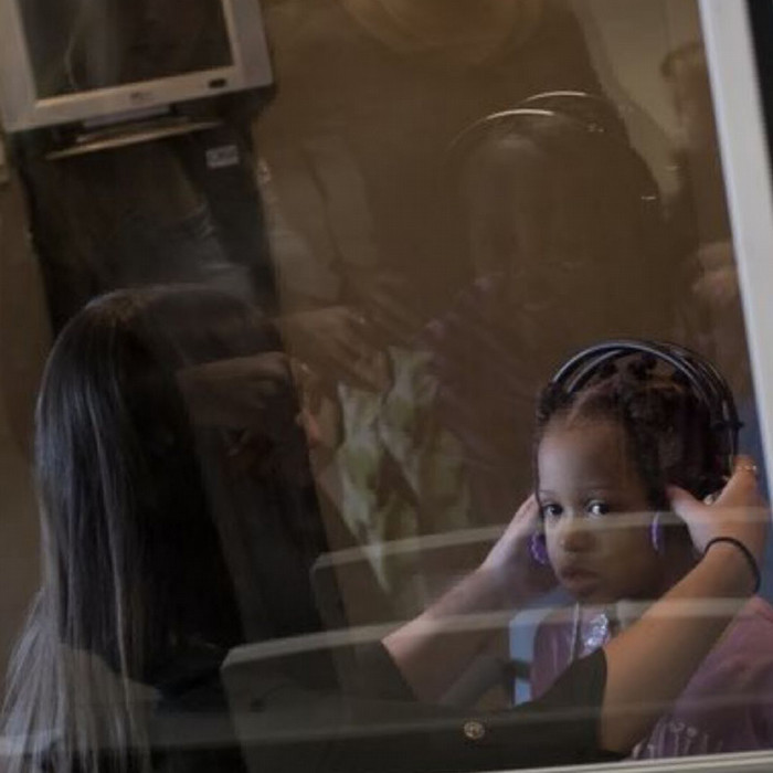 audiology student putting headphones on child