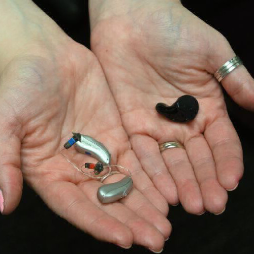 hands holding hearing aids