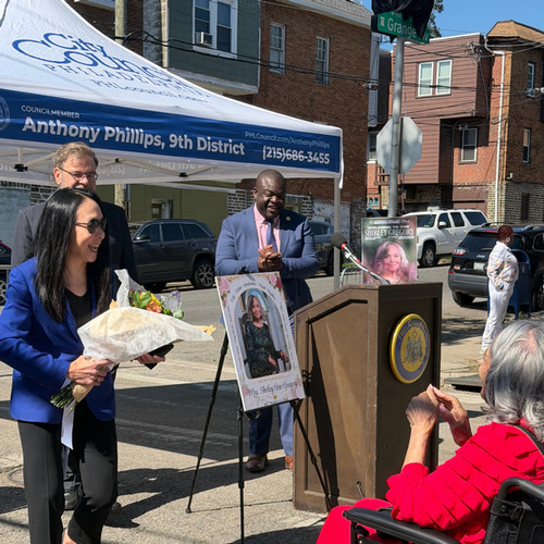 woman receiving flowers at street dedication