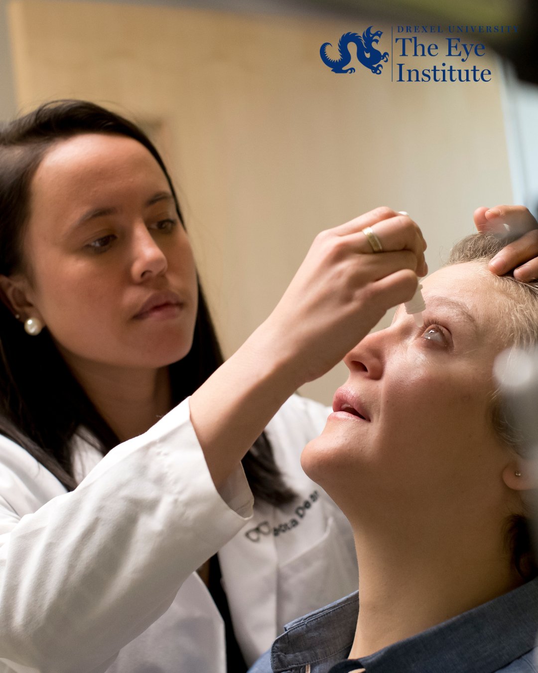 optometrist putting eye drops in patient's eye