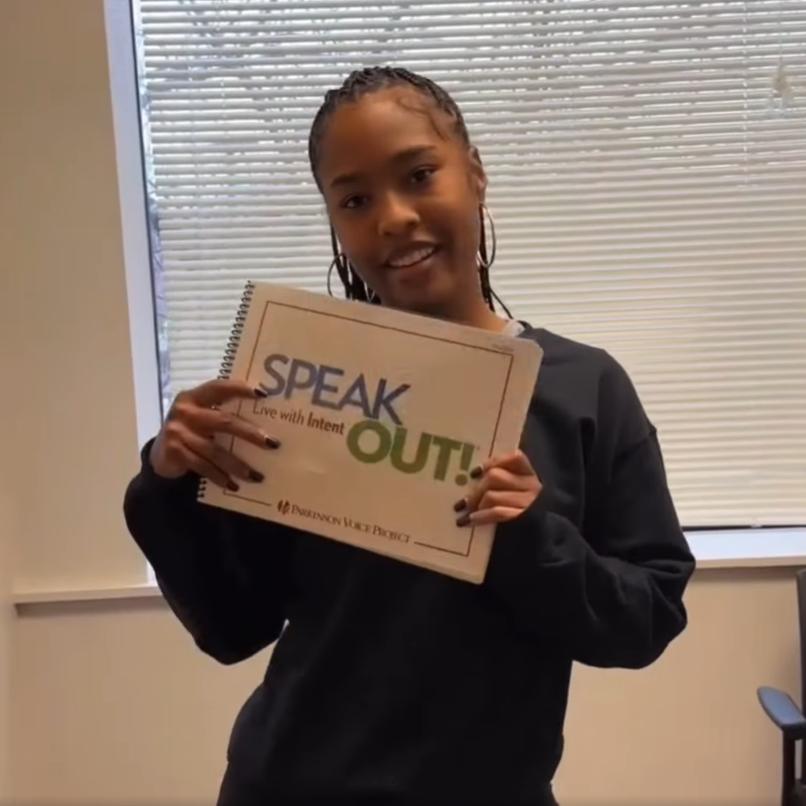 SLP student holding up 'speak out' sign