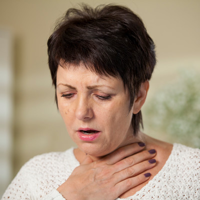 woman holding her throat