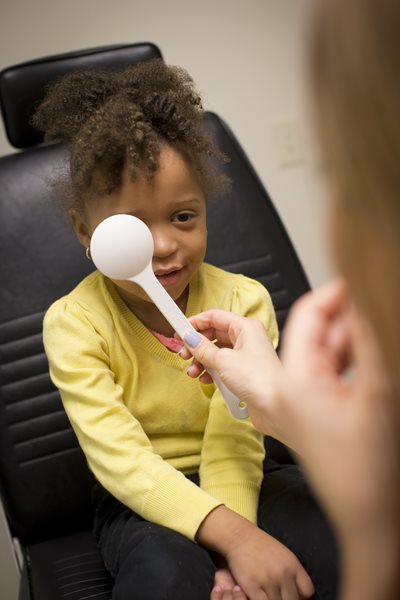image of girl patient with optometrist during eye exam