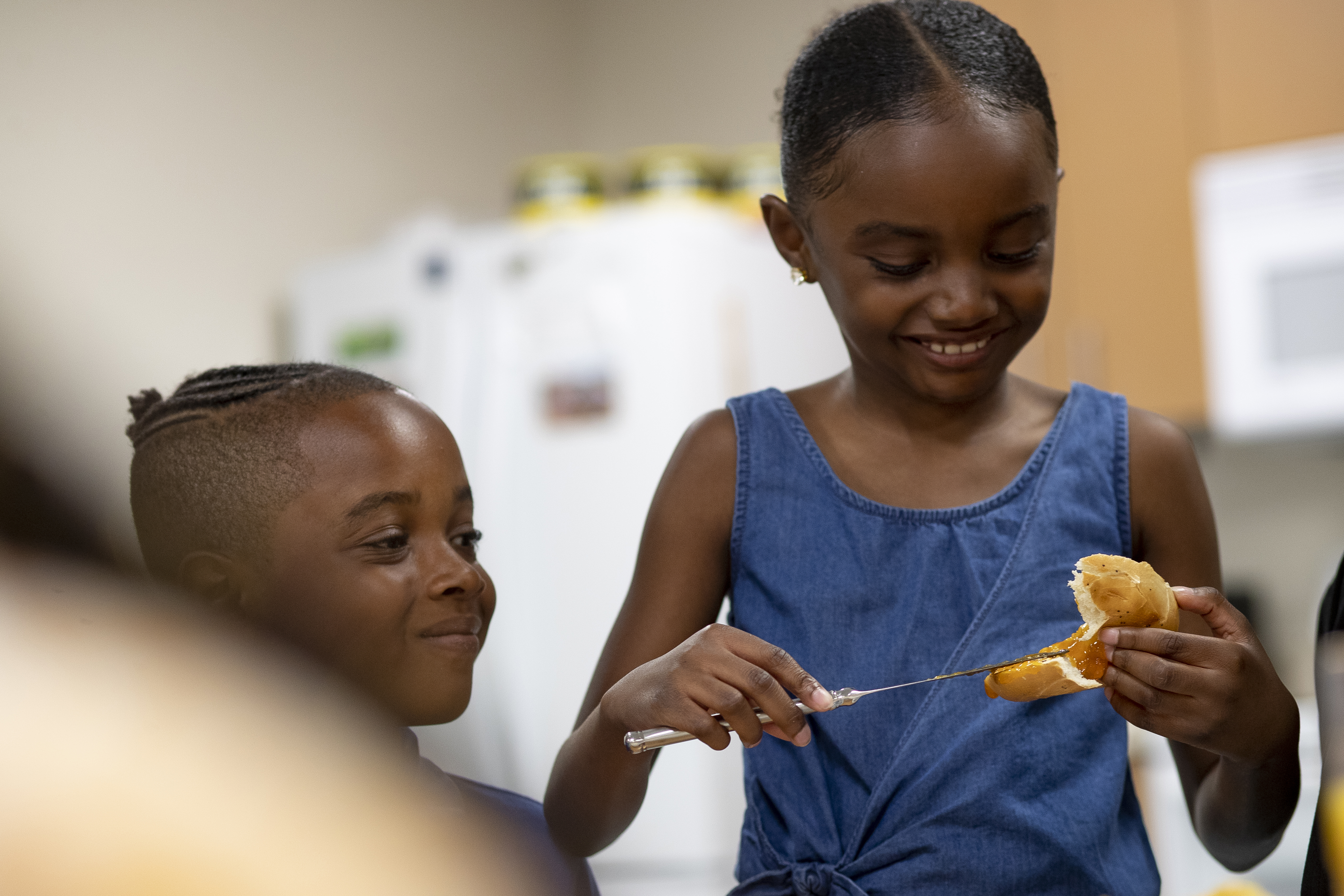Young girl buttering a bagel