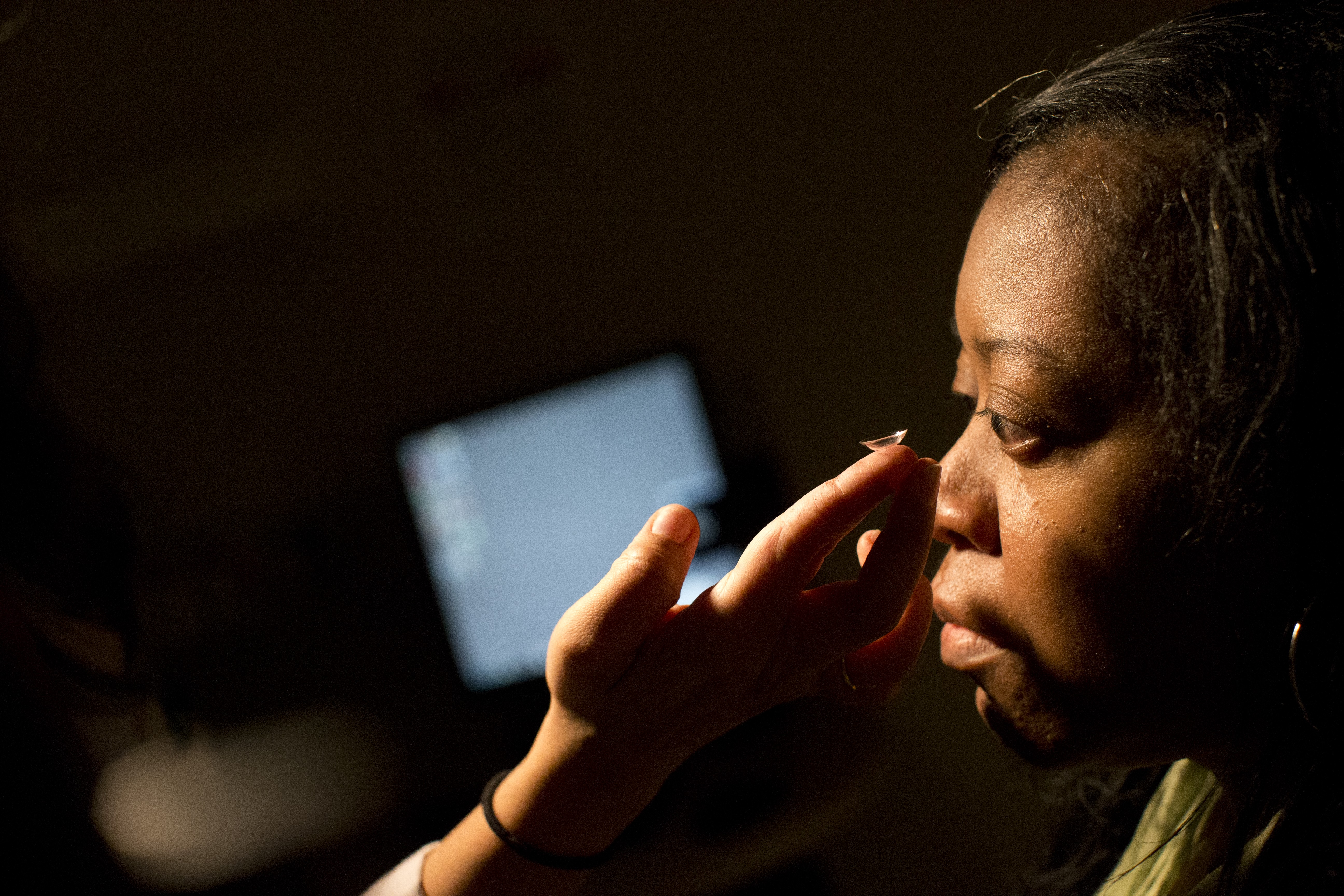 Patient placing a contact in patient's eye