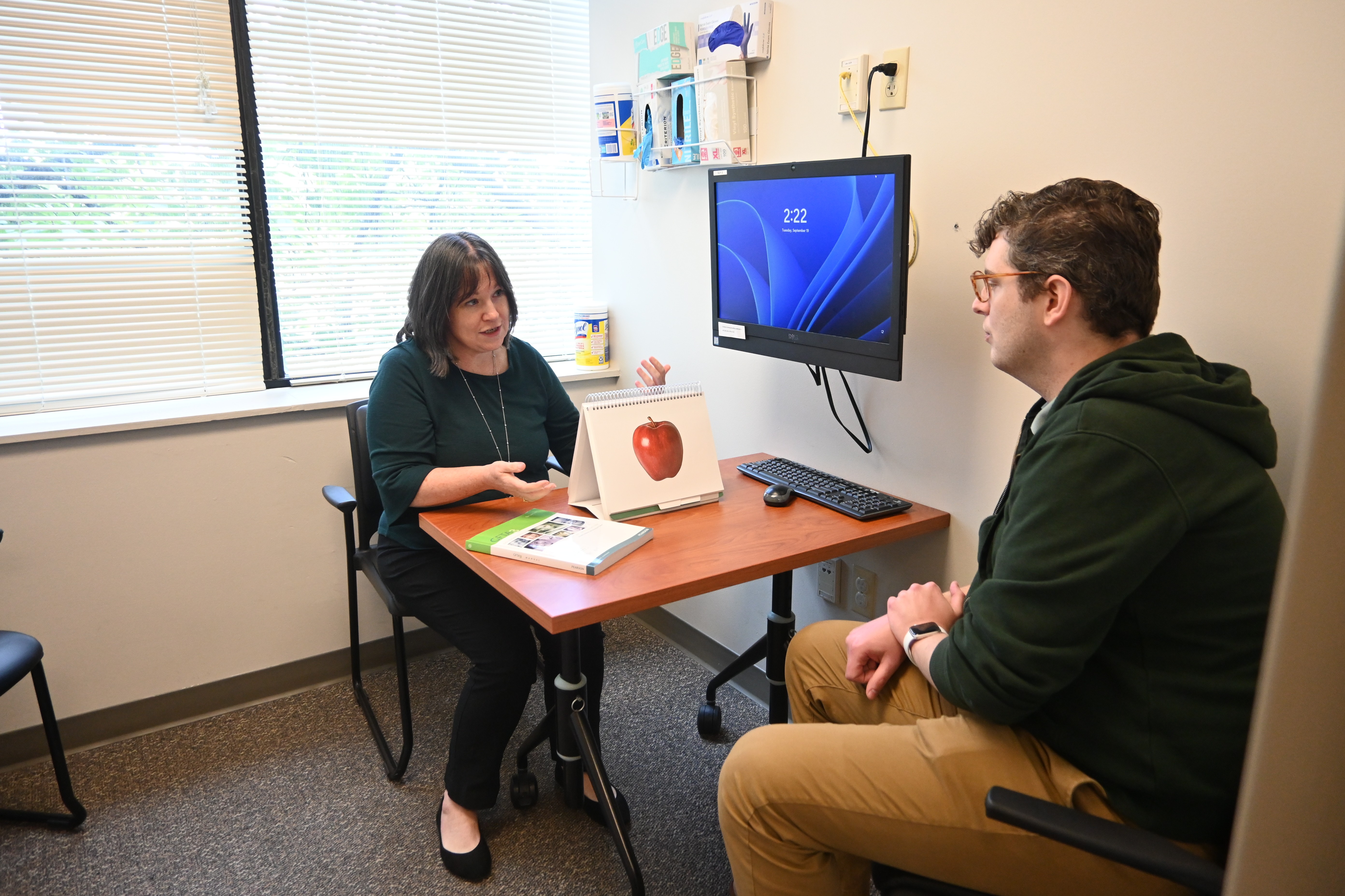 Trish Mayro with client in the exam room at SLI