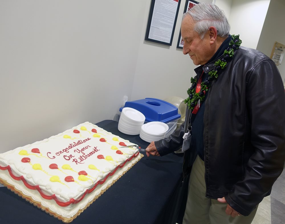 Bernie Blaustein cutting the cake at his Retirement Party