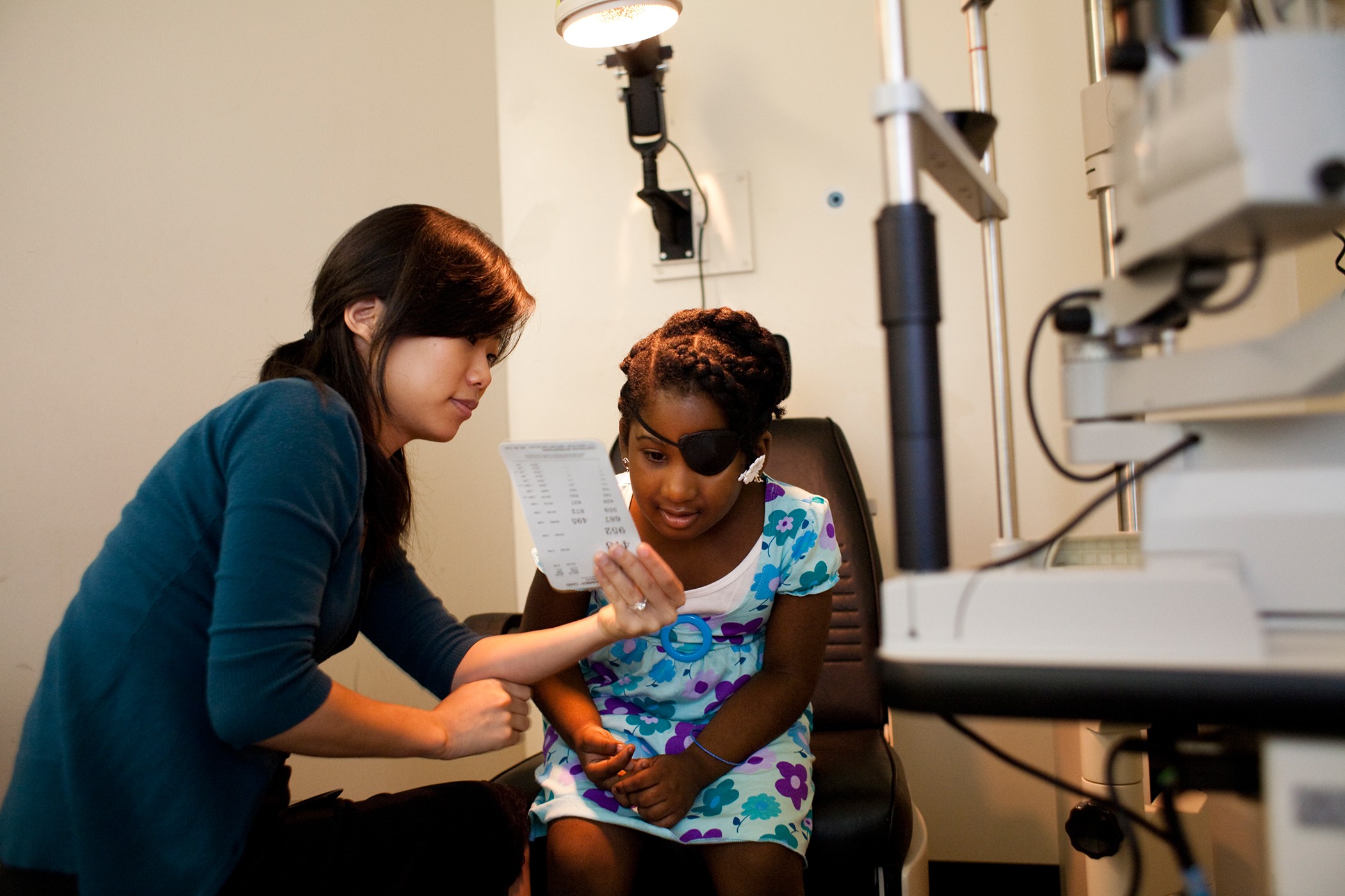 TEI student shows child an eye chart