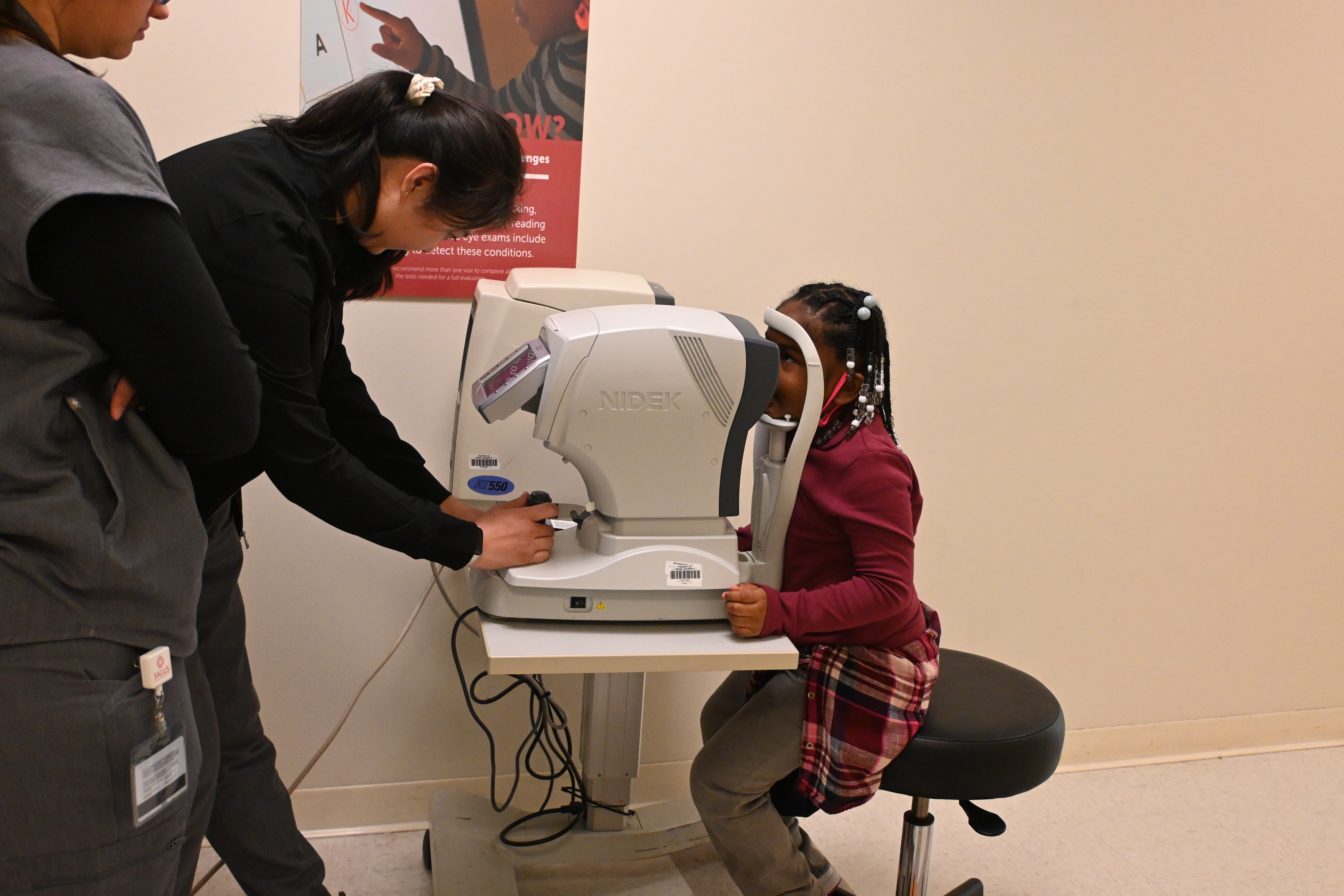 Child looks through device during eye exam at TEI