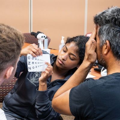 Student conducts eye exam on patient thumbpic