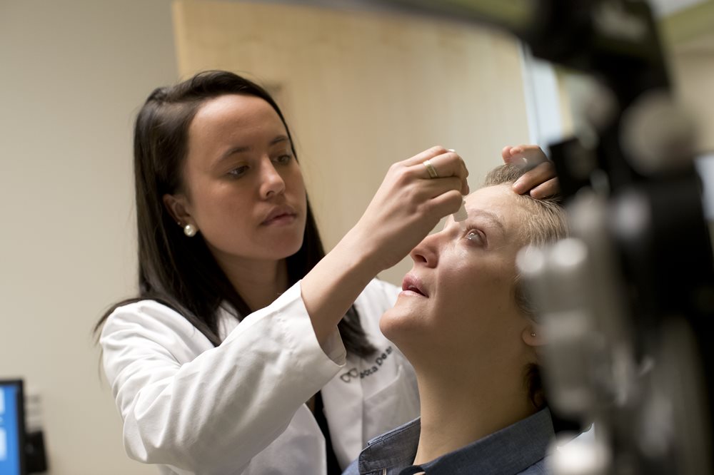 Student putting drops in patient's eye