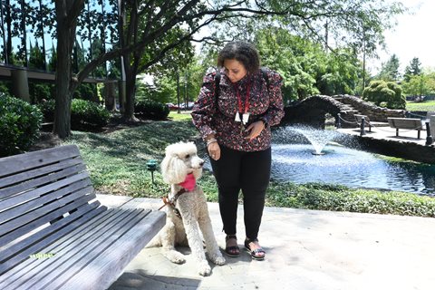 Lachelle giving her guide dog Lyra a treat for following commands