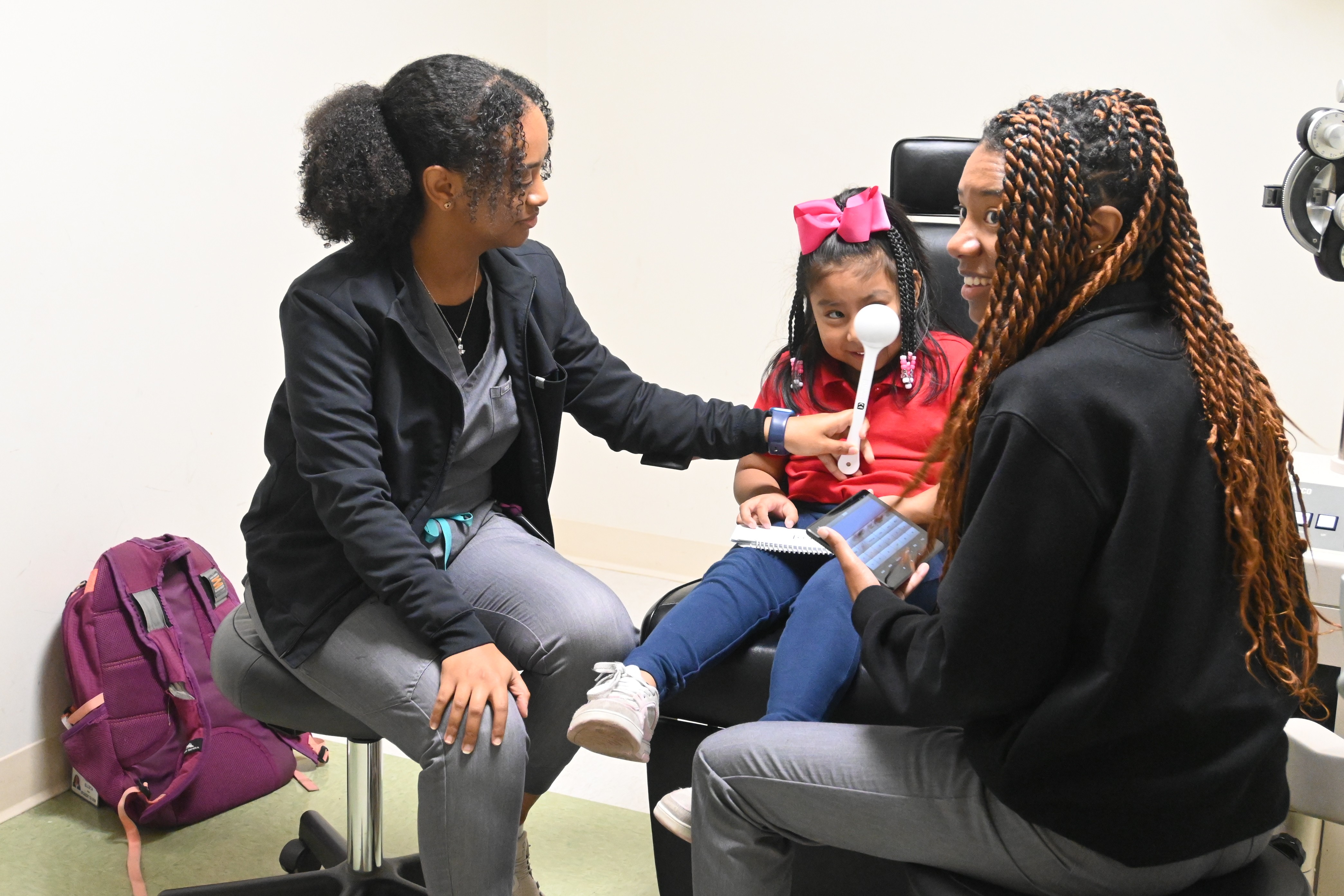 Young female patient gets an eye exam at school