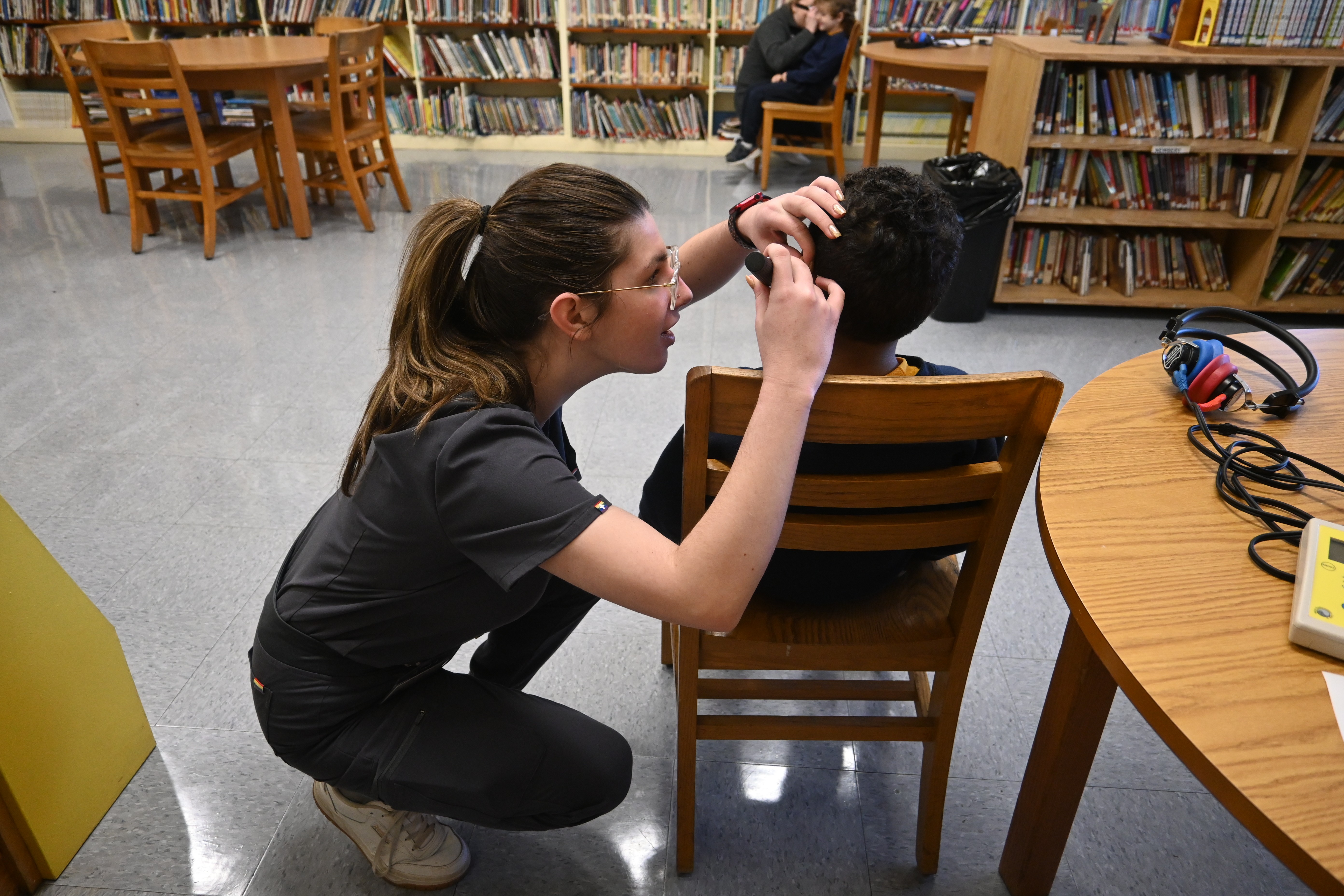 AUD student checks young student's ear