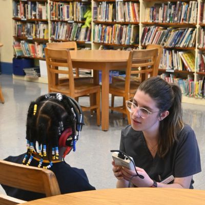 AUD administers hearing test in school library thumbpic
