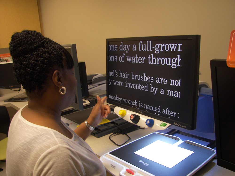 Patient using a low vision device at the Feinbloom Center