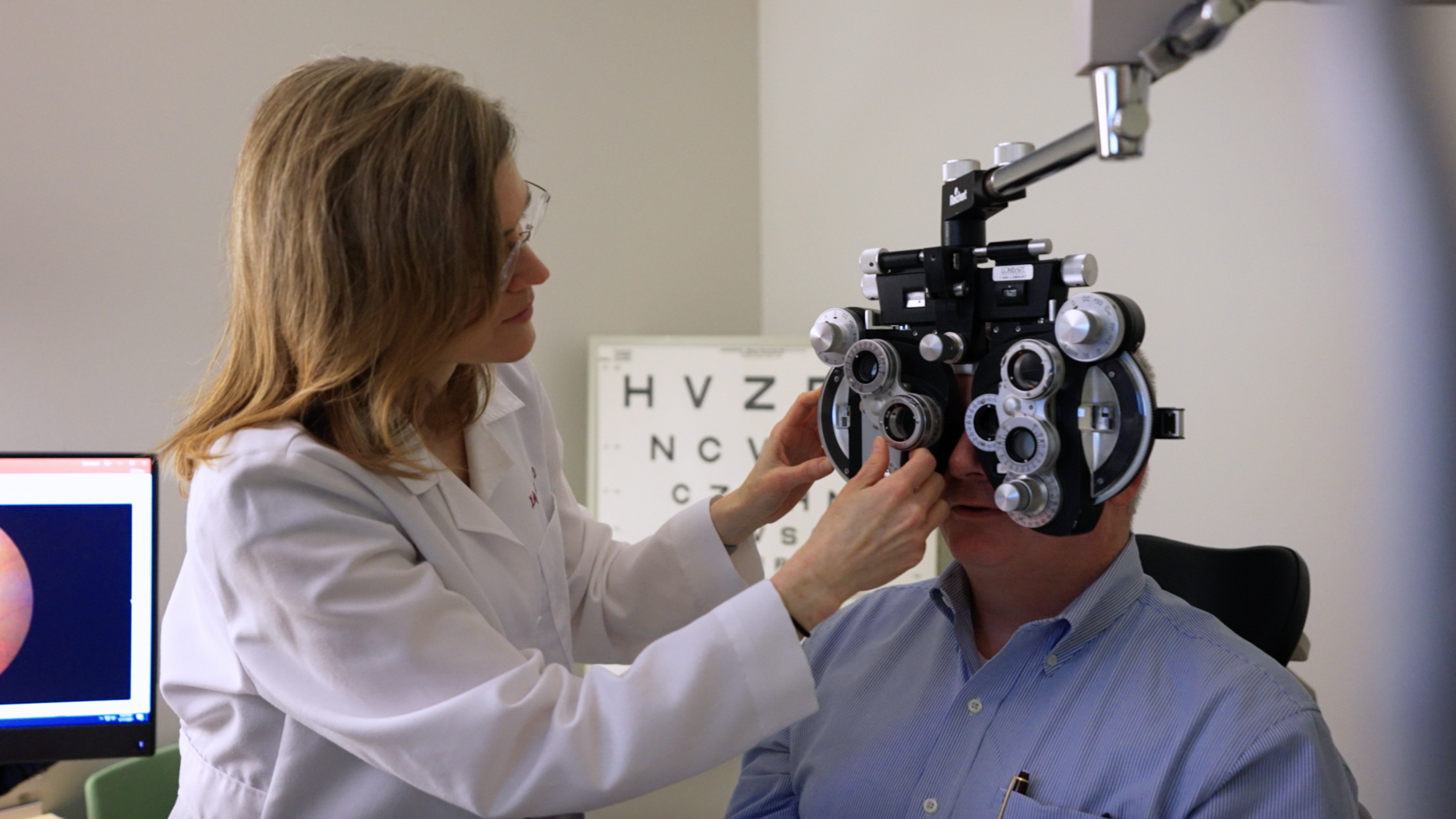 Optometrist performing eye exam on patient