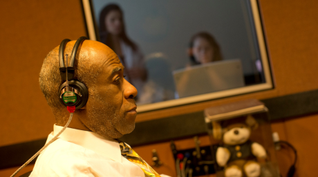 Elderly patient at PEI sitting with headphones in a sound booth during an exam
