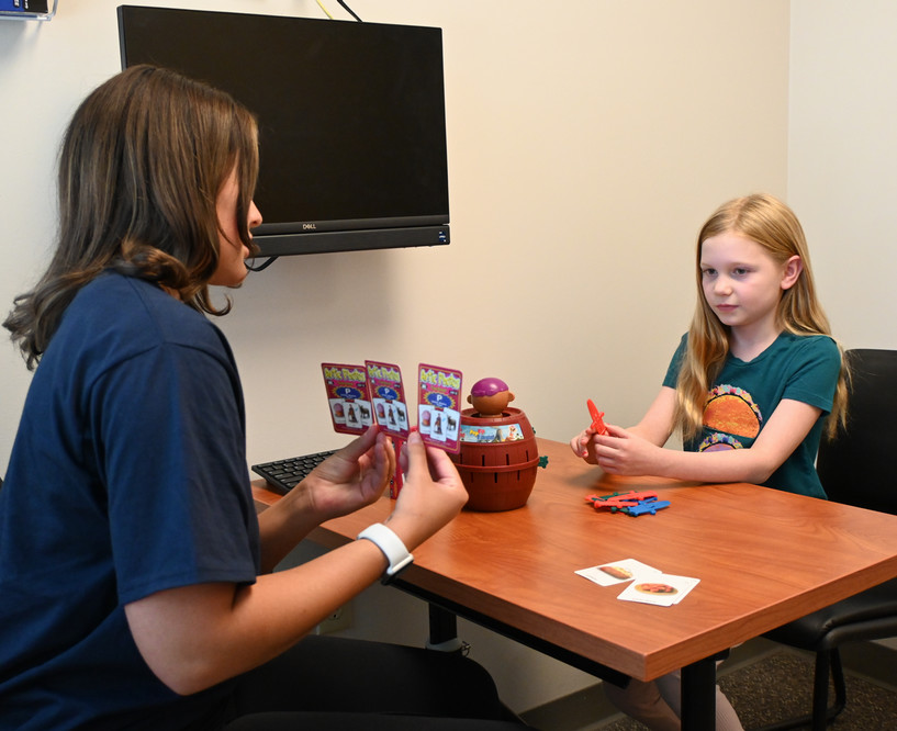 SLP student playing a game with a pediatric patient