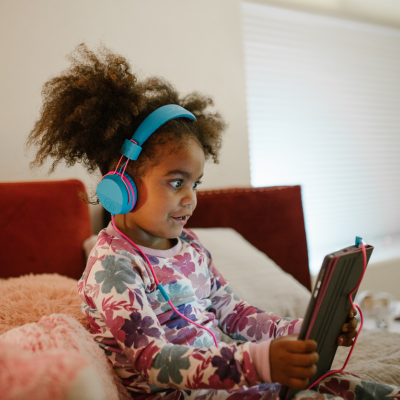 child wearing headphones and using tablet